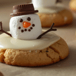 Melted Snowman Peanut Butter Cookies decorated with marshmallows and icing on a cooling rack.