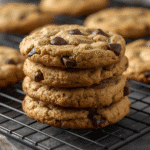 Alt: Golden chocolate chip cookies on parchment with melted chips and sea‑salt flakes​​