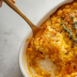 Alt Text: Nantucket Corn Pudding served as a Thanksgiving corn pudding side dish, decorated with fresh parsley on a festive dinner table.