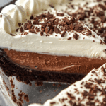 A full 9-inch easy chocolate cream pie in a glass dish, showing the contrast between the black cookie crust and the white whipped topping.