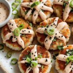 Searing Asian-style tuna cakes with spicy mayo in a pan.