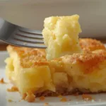 A golden brown Pineapple Bake in a white ceramic dish, showcasing a bubbly crust and tropical paradise vibes.