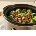 Close up of slow cooker beef and broccoli dinner showing the glossy savory sauce and bright green broccoli.