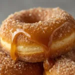 Freshly baked Caramel Apple Cider Donuts with a shimmering salted caramel glaze and autumn spices.