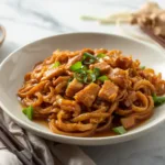 Close up of glossy rice noodles and chicken