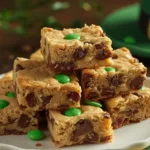 A stack of St. Patrick’s Day Chocolate Chip Cookie Bars showing green candies.